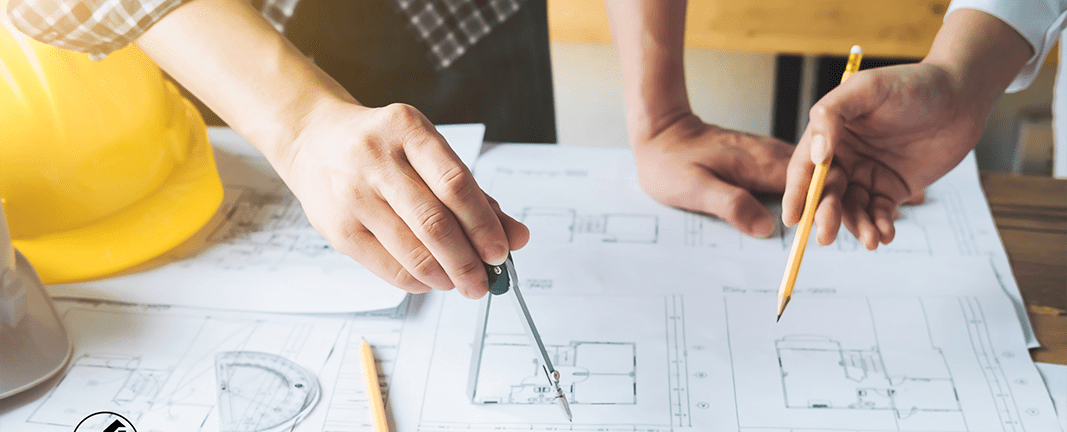 Home remodeling contractors reviewing house plans Reimagine Renovation