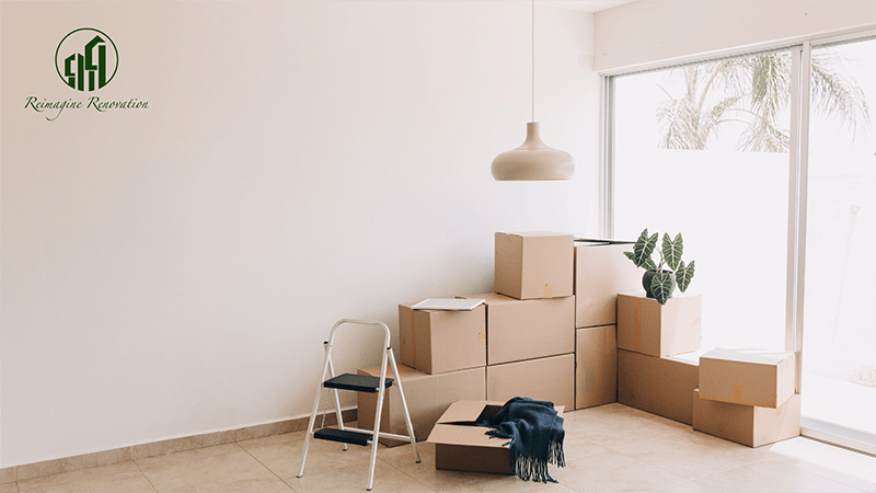 A bunch of moving boxes in the corner of an empty room