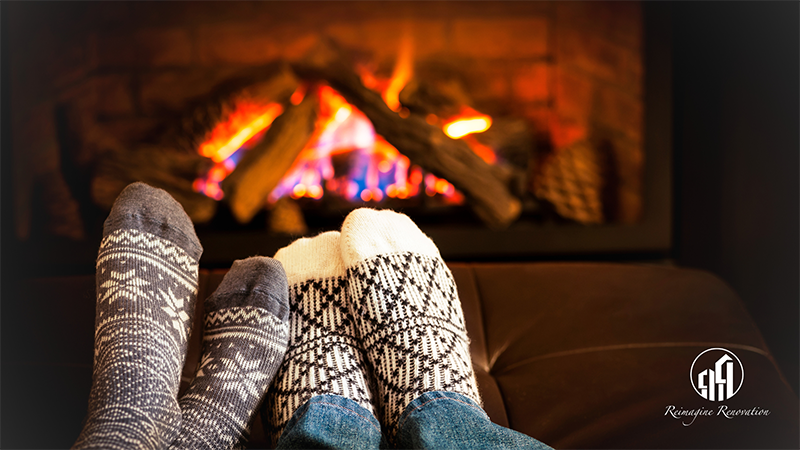 Two people sitting in front of a roaring fire keeping warm